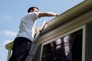 man cleaning roofing gutters Idaho Falls, ID